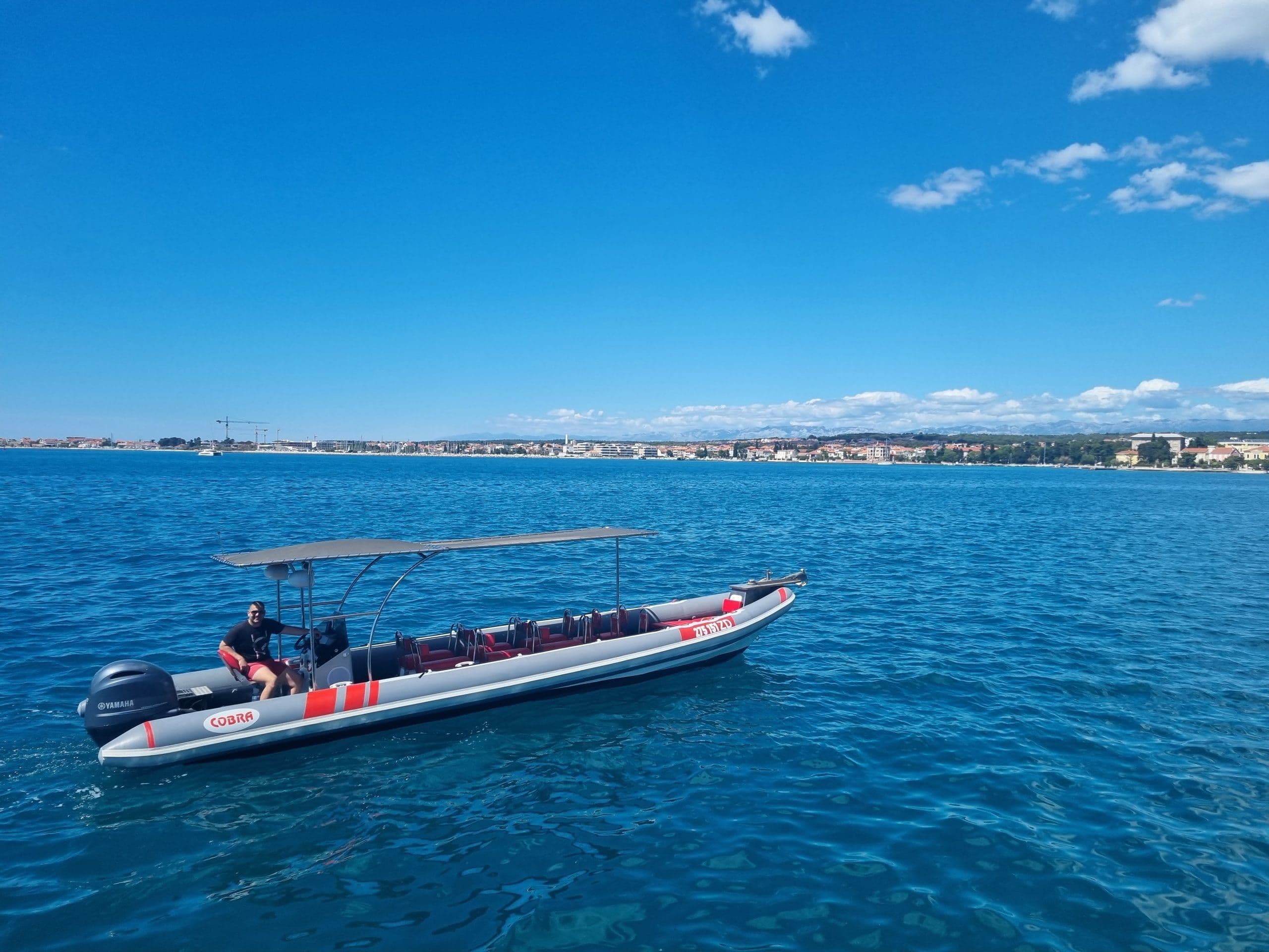 Aerial view of guests swimming from speedboat in turquoise Adriatic